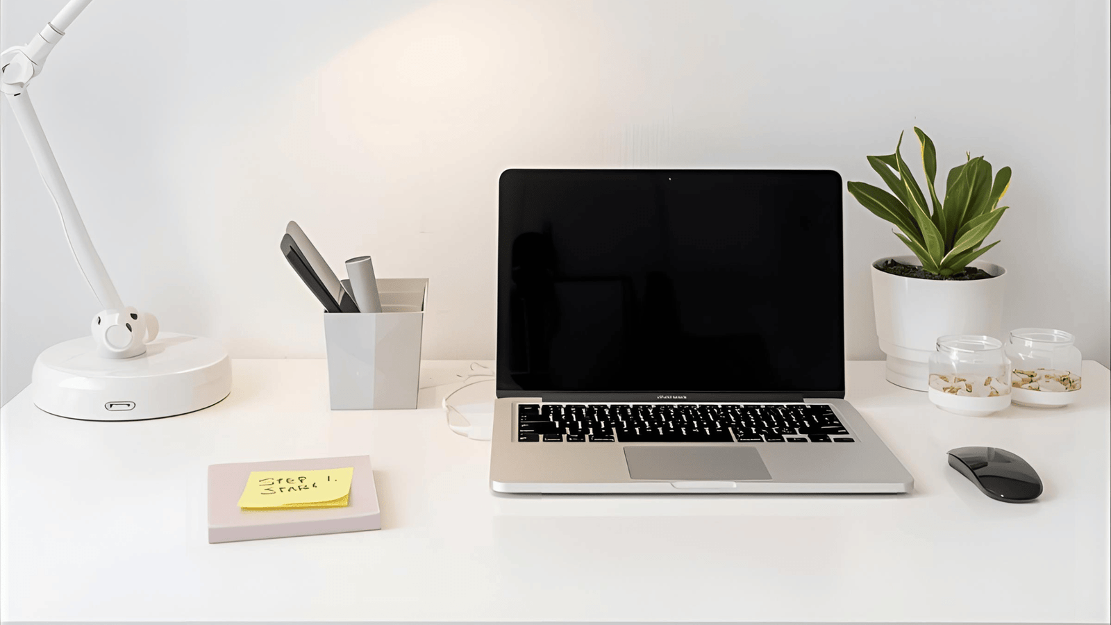 a laptop computer sitting on a desk with a lamp